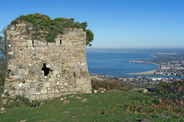 Fototapeta na wymiar Antigua torre militar de vigilancia en el monte Jaizkibel y la costa del suroeste francés.