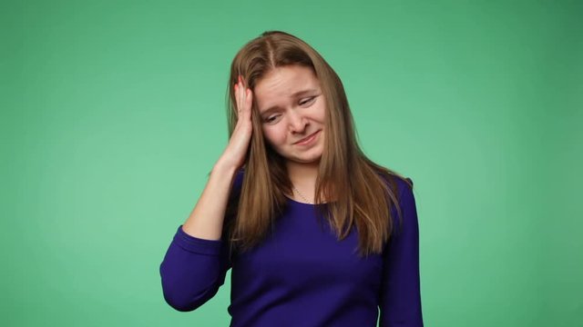 Young woman grabbing the head, chroma key green screen background