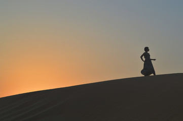 girl in the setting sun in the desert