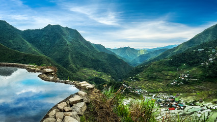 Fototapeta na wymiar Amazing panorama view of rice terraces fields in Ifugao province mountains under cloudy blue sky. Banaue, Philippines UNESCO heritage