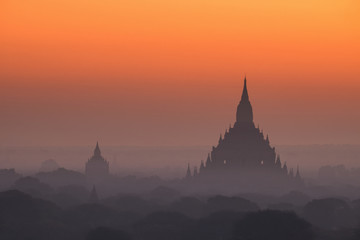 Amazing misty sunrise colors and silhouette of ancient Myauk Guni Pagoda. Architecture of ancient Buddhist Temples at Bagan Kingdom. Myanmar (Burma) travel destinations