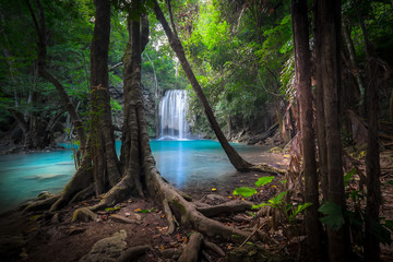 Jangle landscape with flowing turquoise water of Erawan cascade waterfall at deep tropical rain forest. National Park Kanchanaburi, Thailand