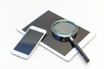 smart phone, tablet pc and magnifying glass, searching or checking concept