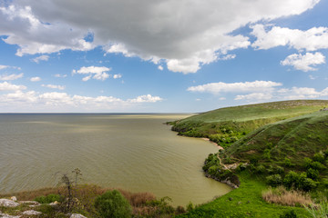 Fototapeta na wymiar Beautiful green landscape by the lake and white clouds on blue sky