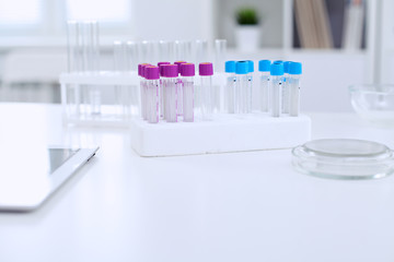 Research laboratory working space. Test tubes and tablet PC are lying at the table. Medical equipment. Blood test