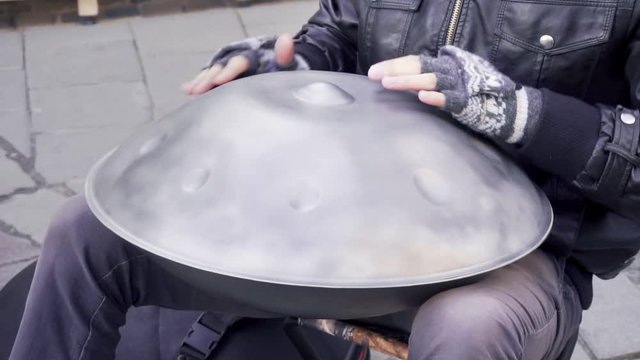 Man plays hang drum in the street