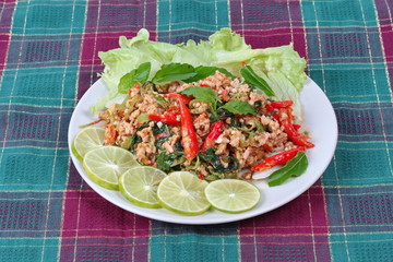 Popular Thai food,Fried spicy basil with minced pork topped sliced green lemon and and lettuce .