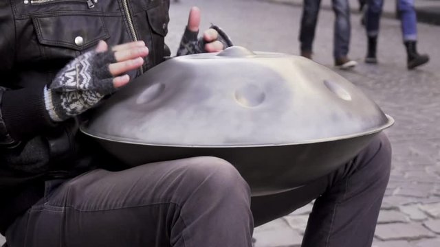 Man plays hang drum in the street