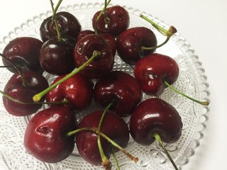 Cherries on glass dish on white background