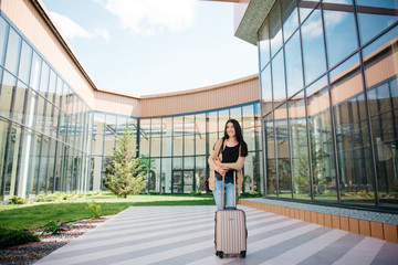 young attractive girl with a suitcase goes on the terminal