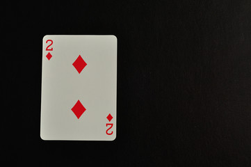 Playing card. Two of diamond isolated on a black background
