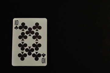 Playing card. Ten of clovers isolated on a black background