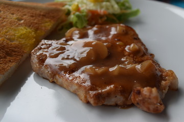 Grilled pork chop with bread.