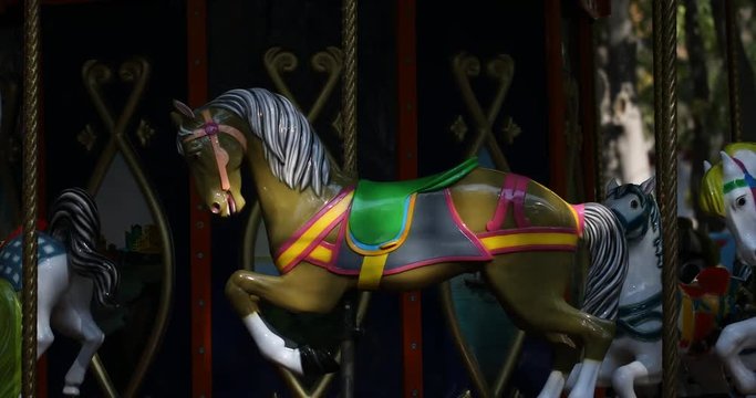 Old French carousel in a holiday park. Merry-go-round with horses.