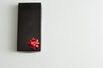 A black gift box with a red bow isolated on a white background