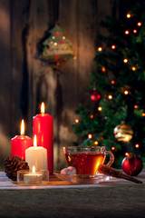 close up view of cup of black tea and candle on color back