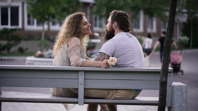 Married couple in the park on a white bench.