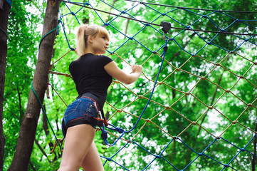 Naklejka na ściany i meble Hiking in the rope park beautiful sports girl