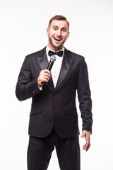 Young man in suit singing over the microphone with energy. Isolated on white background. Singer concept.