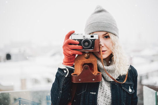 Blond curly girl with film photo camera, winter