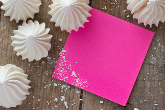 white zephyr and piece of paper on wooden table, mock up