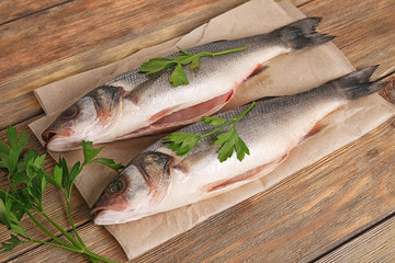 Fresh fish with parsley on wooden background