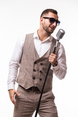 Fototapeta premium portrait of young man in suit singing with the microphone. Isolated on grey background. Singer concept.