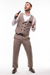 Young man in suit singing over the microphone with energy. Isolated on white background. Singer...