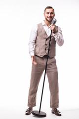 Young showman in suit singing with emotions gesture over the microphone with energy. Isolated on white background. Singer concept.