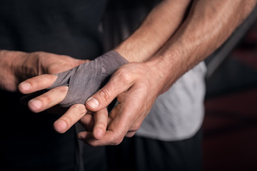 Fototapeta na wymiar Close up trainer wrapping hand of trainee