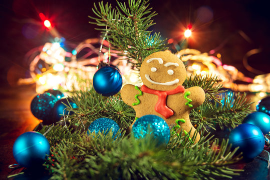 gingerbread man near Christmas tree with toys by garland