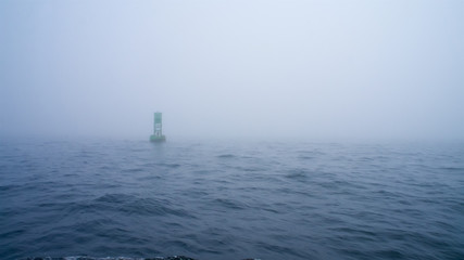 Green channel marker buoy in the fog