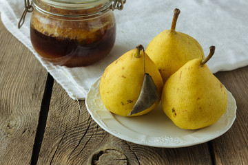Tree yellow pears on white dish and honey