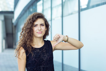 Beautiful curly girl showing thumbs down, negative emotions