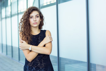 Lone curly girl hugged herself, outdoors