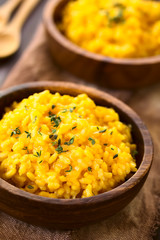 Kürbisrisotto mit frischem Thymian in Holzschüssel, fotografiert mit natürlichem Licht (Selektiver Fokus, Fokus ein Drittel in das Risotto)