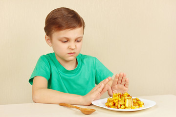 Little boy does not want to eat a fries