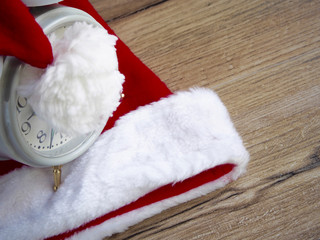 Obraz na płótnie Canvas Santa Claus hat with clock on wood background