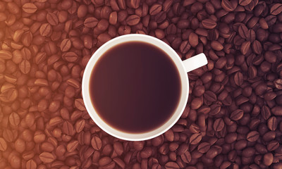 Top view of cup of coffee on its beans, toned