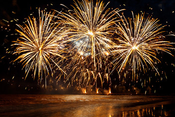 beautiful Golden fireworks over the sea on night sky background