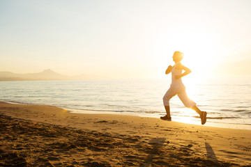 Fototapeta premium Caucasian woman jogging at seashore