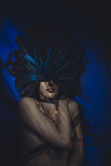 Sexy Beauty with blue feathers on the head, naked brunette woman