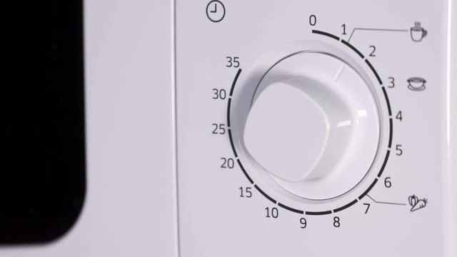  Using microwave oven closing door and setting cooking time from one to nine minutes. Sequence, close-up.