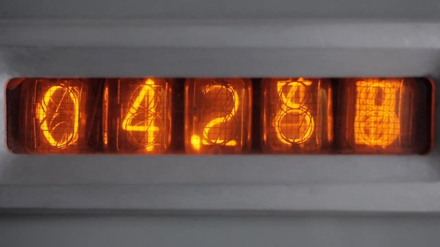 The tube timer counts the seconds. Start counting. Numbers on the display of vintage vacuum tube timer. Close up.
