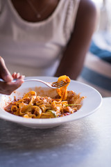 a young African American woman eating pasta