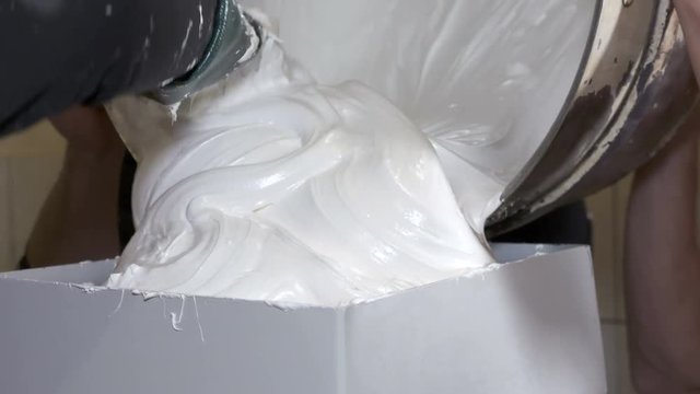 Confectionery factory production of sweet marshmallow zephyr. Closeup of small marshmallow making machine. Workers loading fluffy mixture.