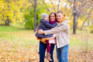 Fototapeta premium Father and Mother With Young Son On hands Autumn Park