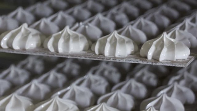Rows of finished marshmallow zephyr at confectionery factory. Sweet white zephyr are cooled before packaging. Pan shot