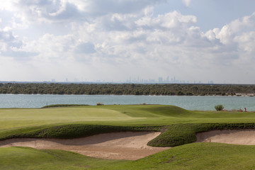 Fototapeta na wymiar Abu Dhabi cityscape with golf field at the foreground