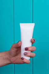 Woman's beautiful hands with care cream tube